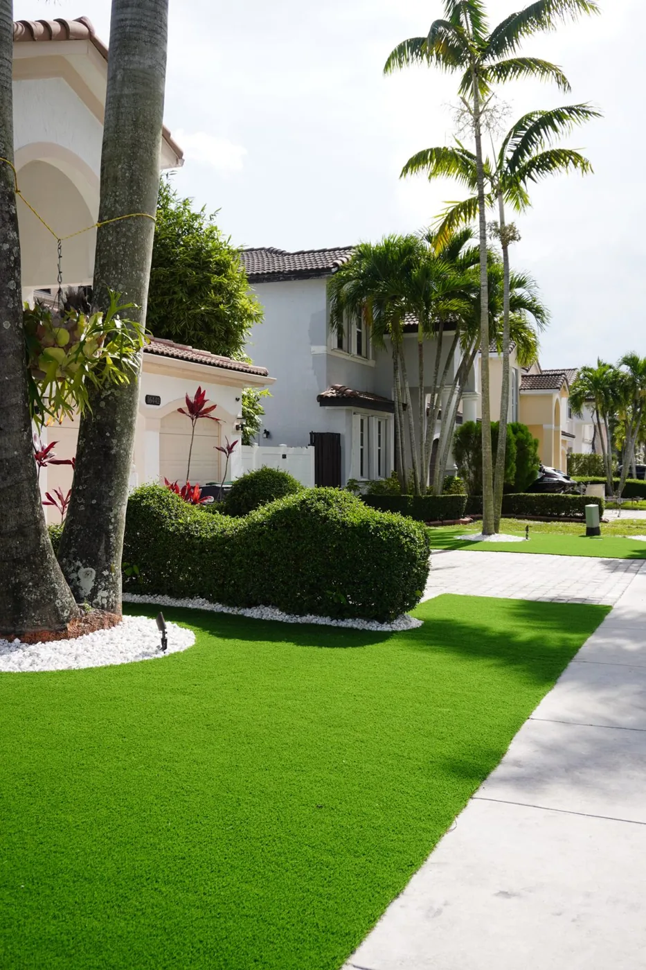 Turf-lined front walkway with palms at a South Florida property