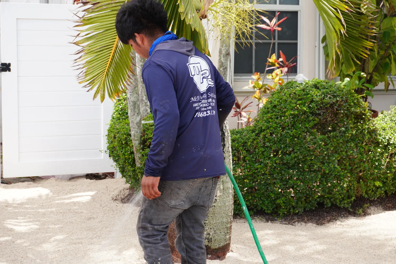 M&R Outdoor Living crew tending landscaping at a South Florida home
