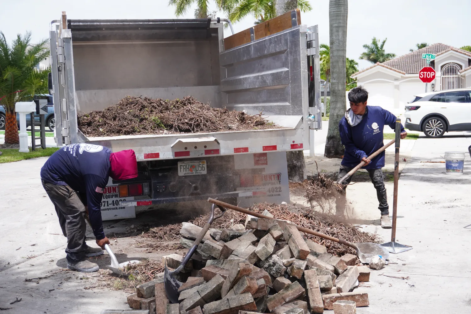 M&R Outdoor Living crew loading debris into the truck